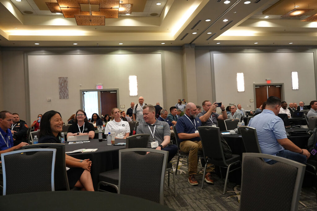 Audience seated in a ballroom during a Summit session