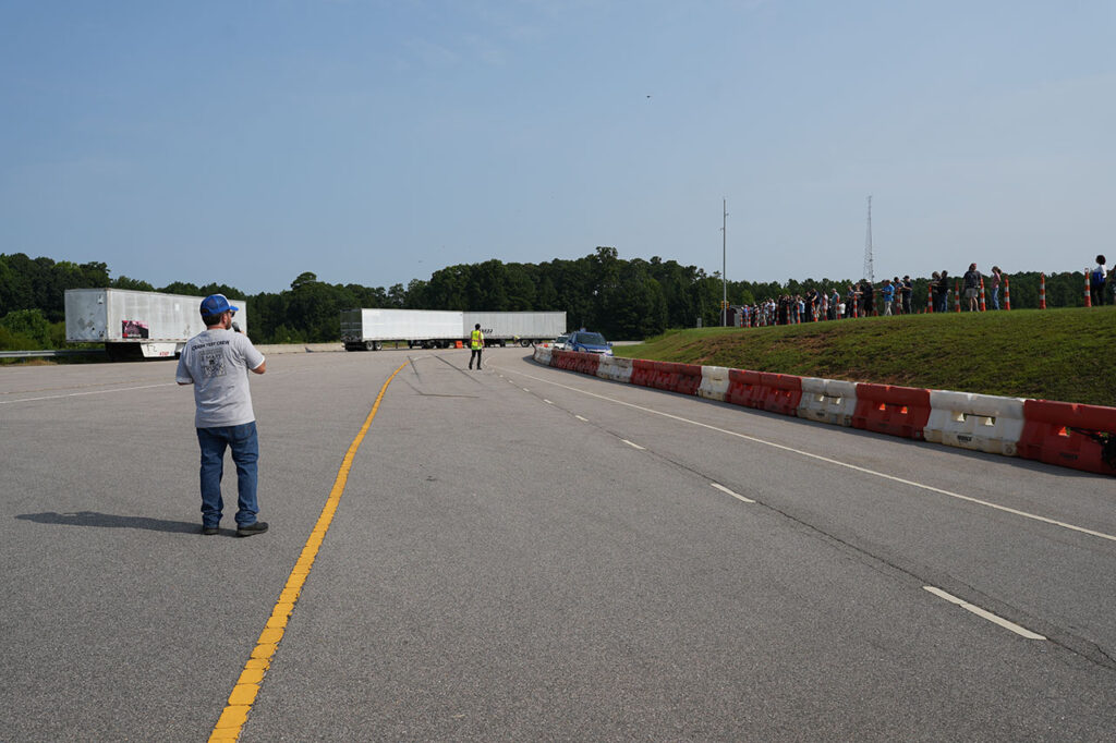 Underride crash-test course with safety barriers and observers