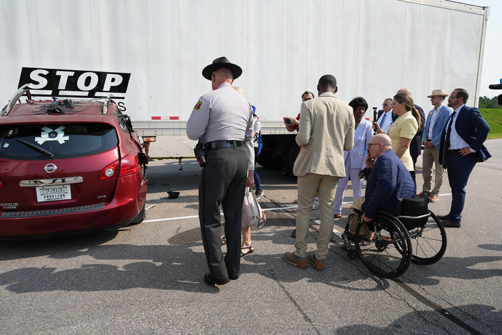 Attendees examining a damaged vehicle after the underride test
