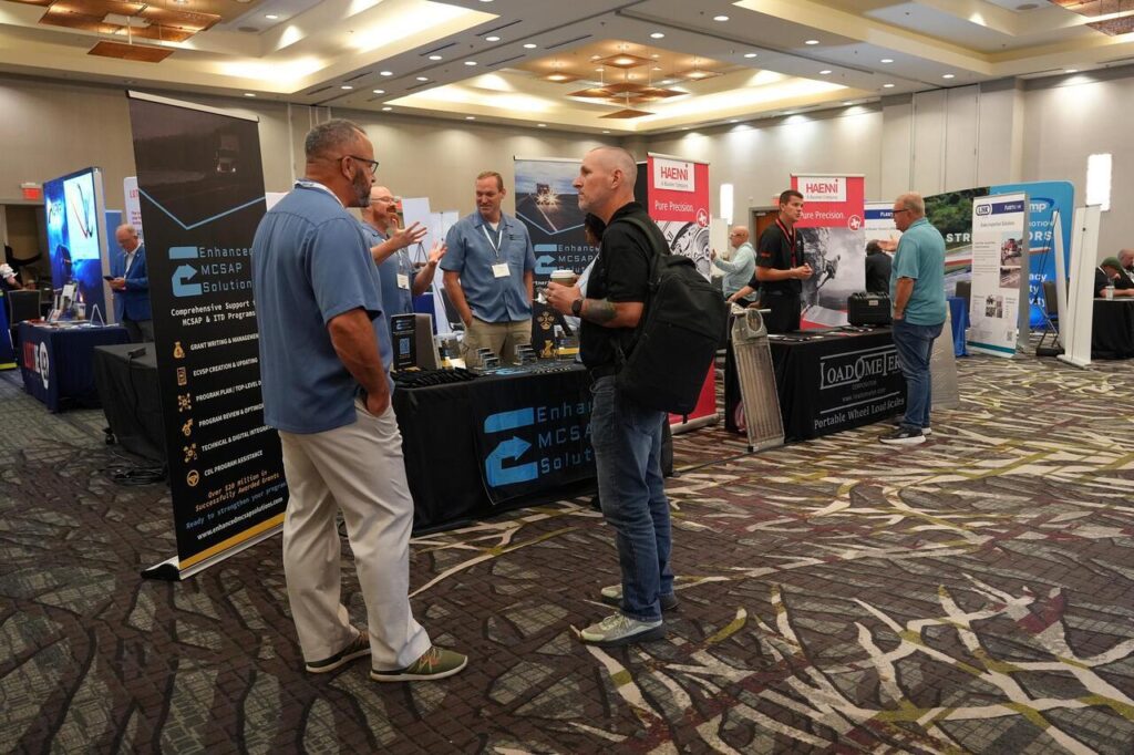 Attendees and exhibitors networking at a professional trade show in a large convention hall