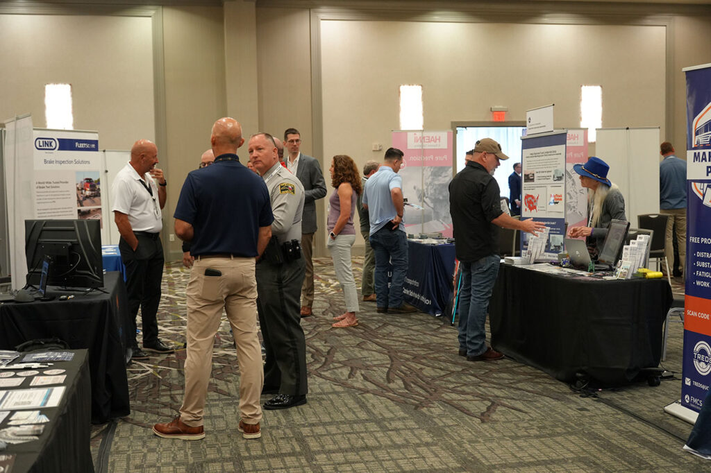 Attendees and exhibitors talking inside the Summit exhibit hall