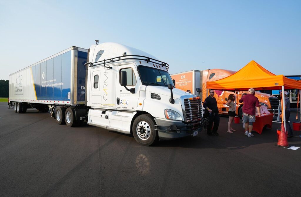 White semi-truck with CARMA and ACE branding on display at an outdoor event