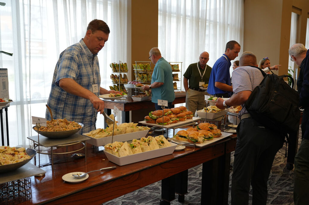 Attendees selecting food from the Summit lunch buffet