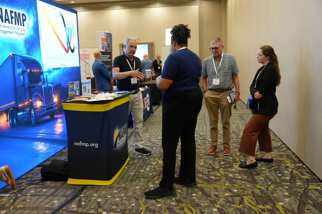 Attendees gathered around a commercial vehicle technology exhibit